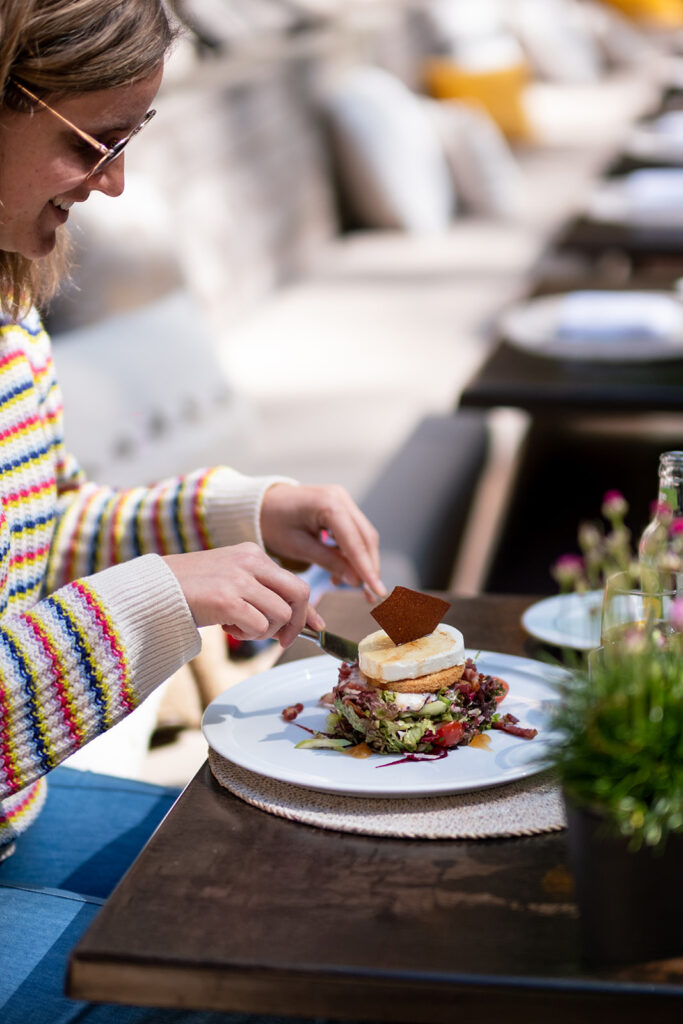 Gast geniet van een voorgerecht bij Jardin Public