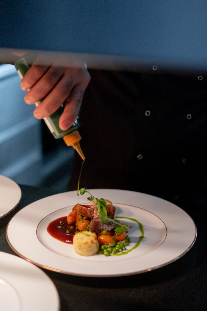 De chef werkt een bord af bij Jardin Public